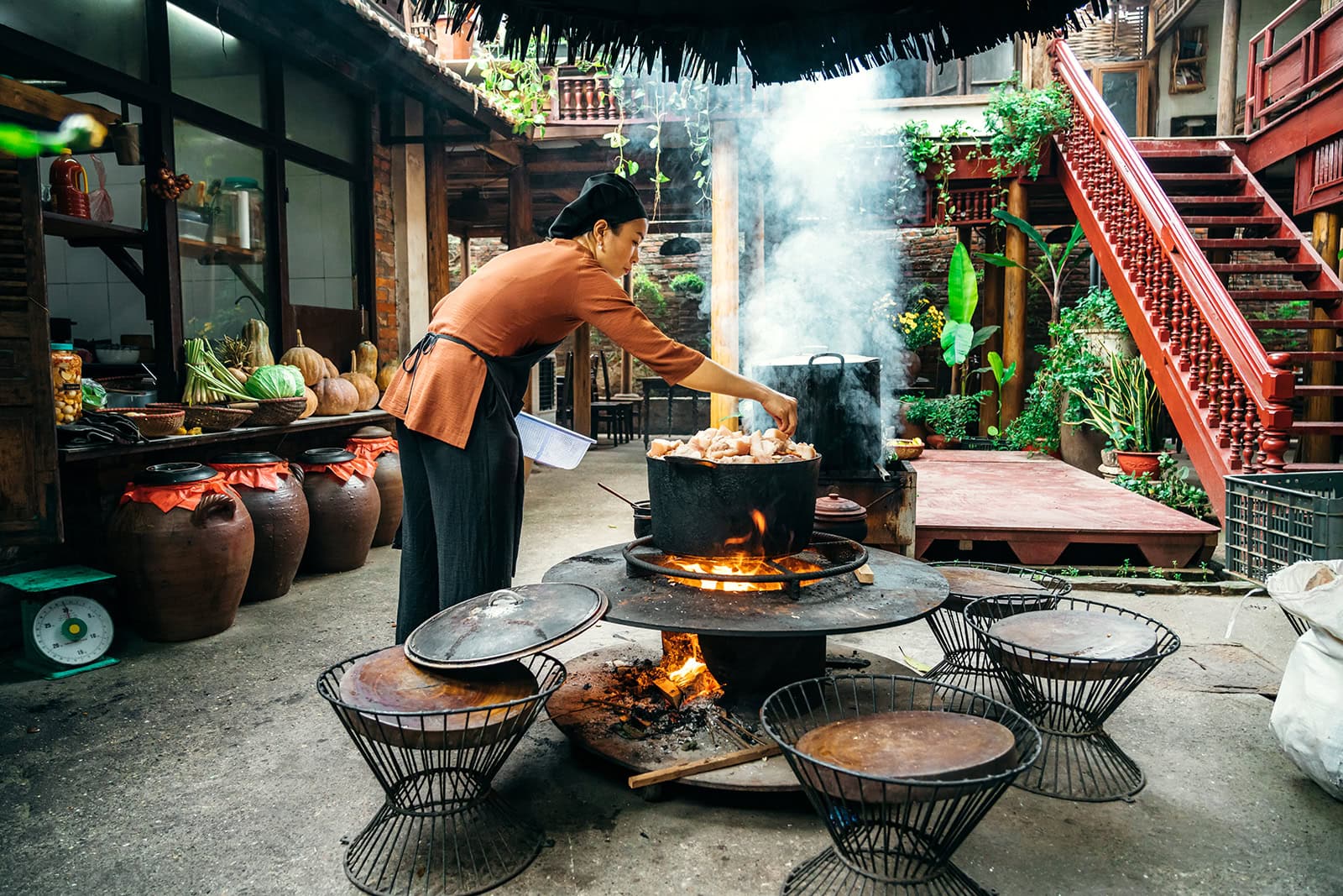 Gekochte Hühner in einem Kochkessel auf offenem Feuer, traditionelles Kochverfahren, authentisches asiatisches Essen, Outdoor-Kochumgebung, ländliches Ambiente.